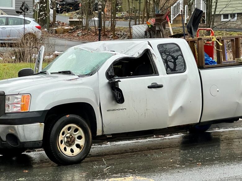 a white pickup truck with a dent on the hood