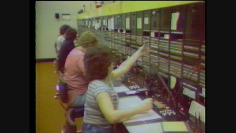 An archival still of employees working at a switchboard. 