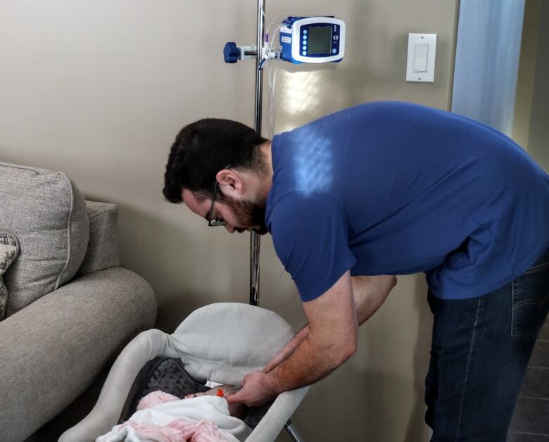 Braeden Dempster adjusts the feeding tube of his baby daughter Amadea.