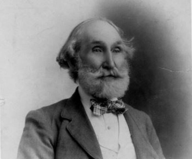 black and white photo of man with white beard and bow tie