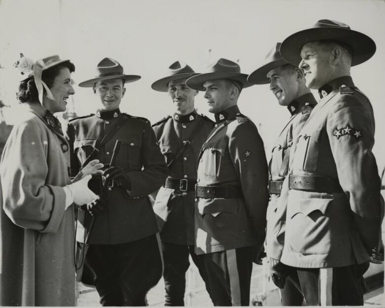 A person takes a photograph of members of the Royal Canadian Mounted Police.