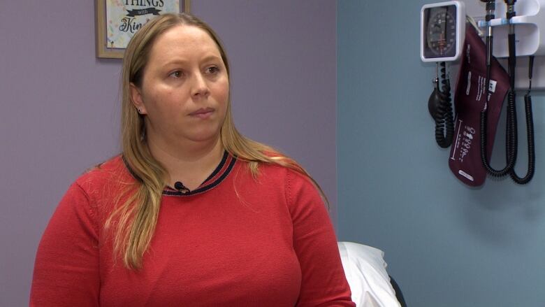 A woman in a doctor's office looks at the camera