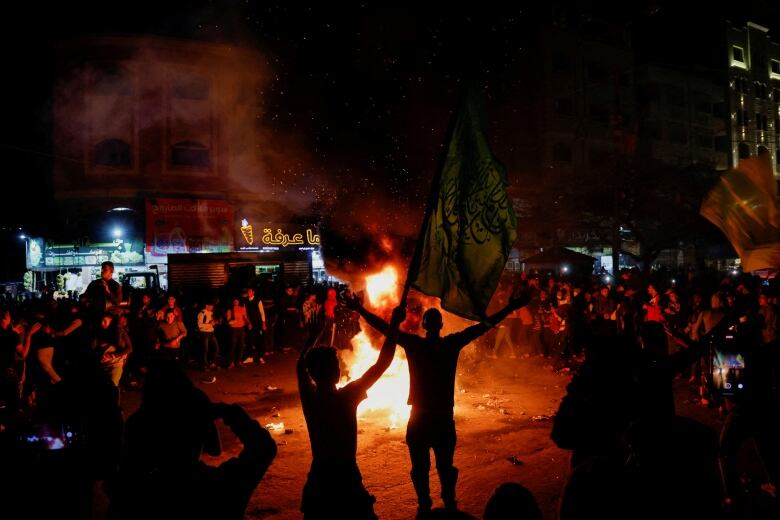 People gather around a bonfire.