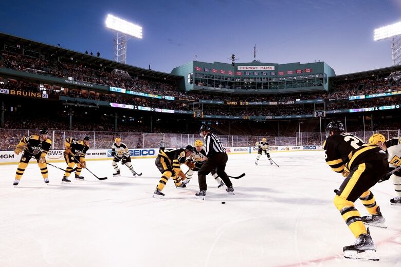 A hockey game is played outdoors at what is normally a baseball field.