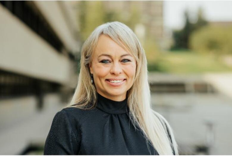 A woman smiles and poses for a photo.