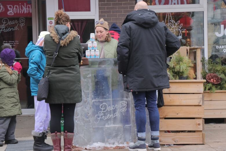 Customers purchase a beer over a bar made of ice. 