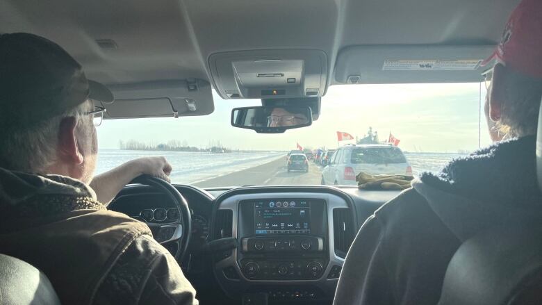 Two men sit in a car.