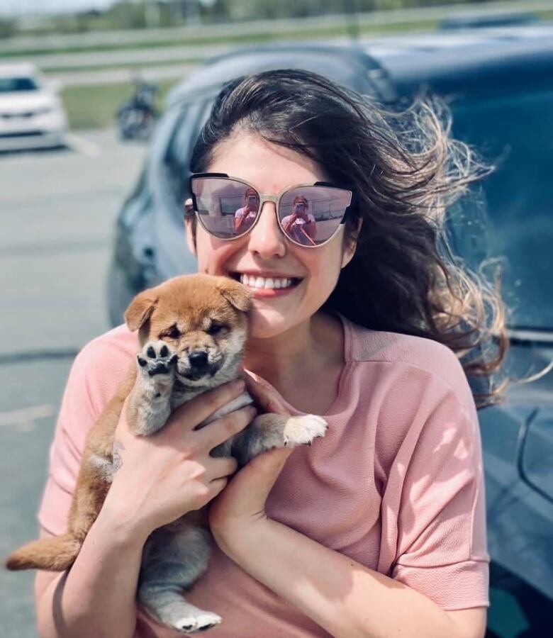 A woman holds a shiba inu