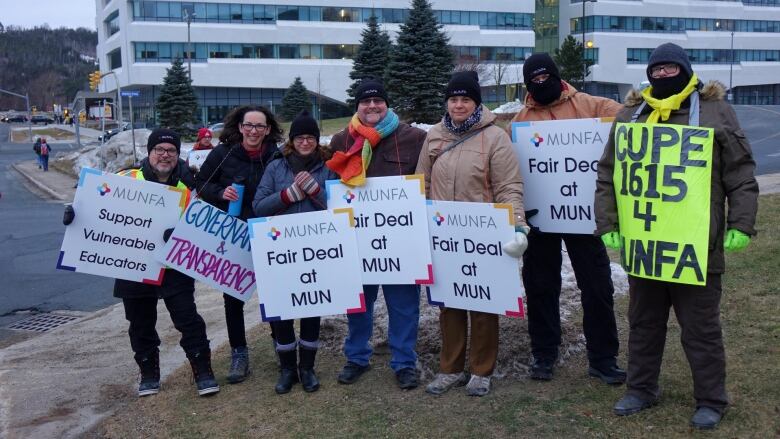 A group of people holding signs that say 