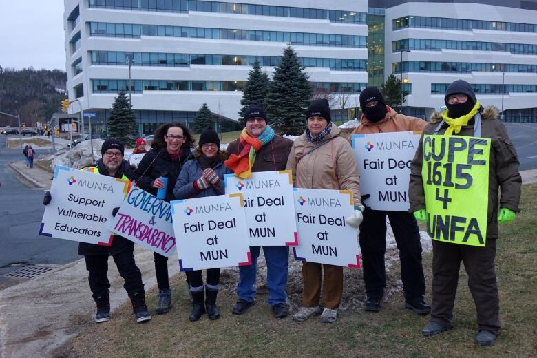 A group of people holding signs that say 