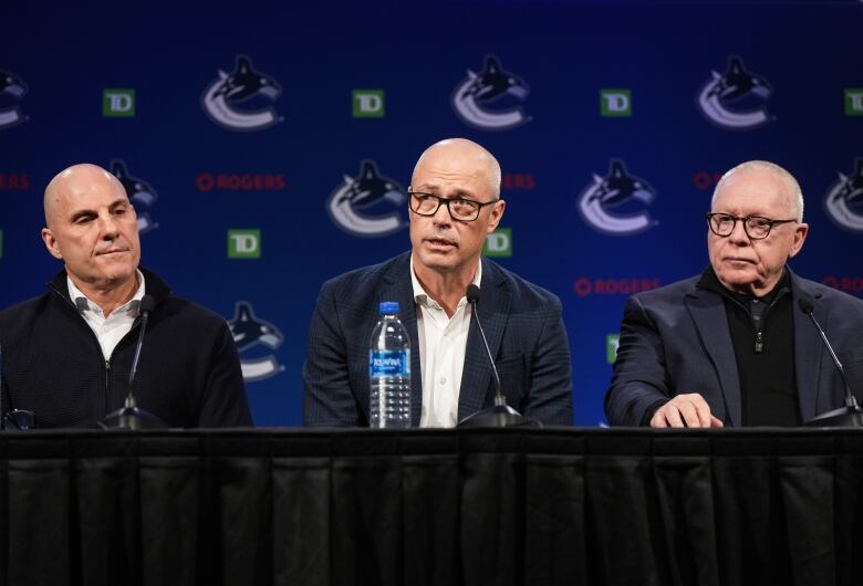 Vancouver Canucks head coach Rick Tocchet, from left to right, general manager Patrik Allvin and president of hockey operations Jim Rutherford at a news conference.