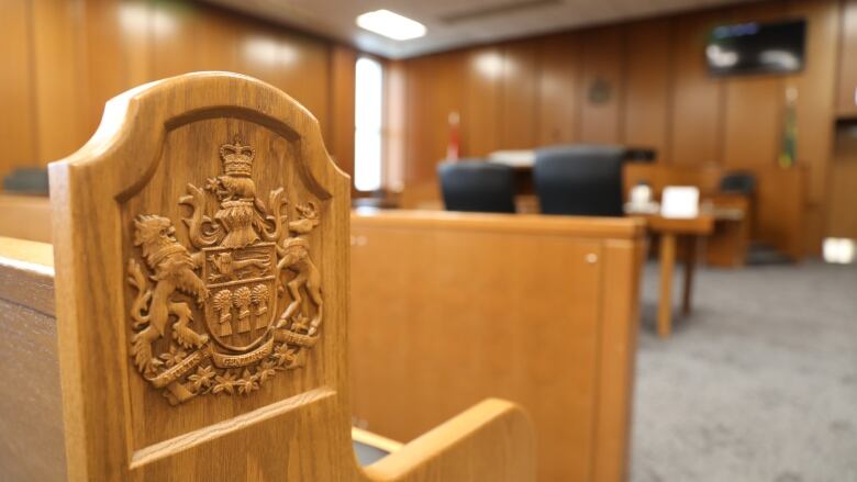 File - The Coat of arms of Saskatchewan on a bench in an empty courtroom at Saskatoon Court of King's Bench.