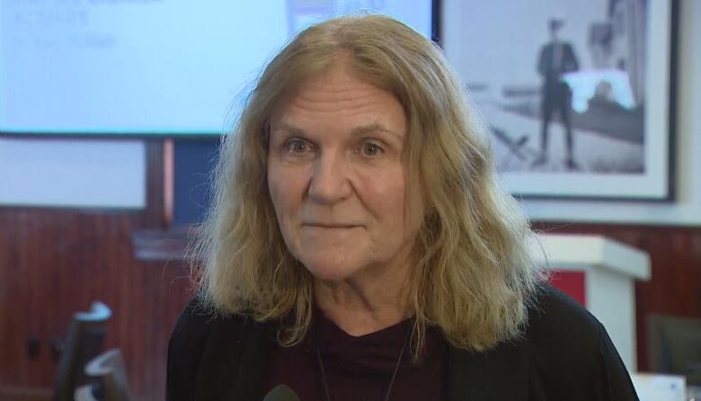 A headshot of a middle-aged woman with shoulder-length blond hair. 