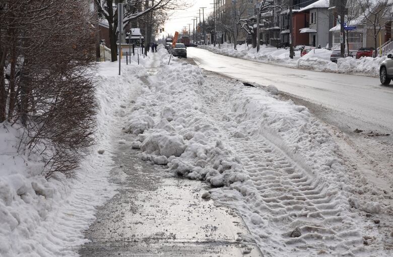 A section of sidewalk on Ottawa's Holland Avenue is blocked by snow from a collapsed snowbank.