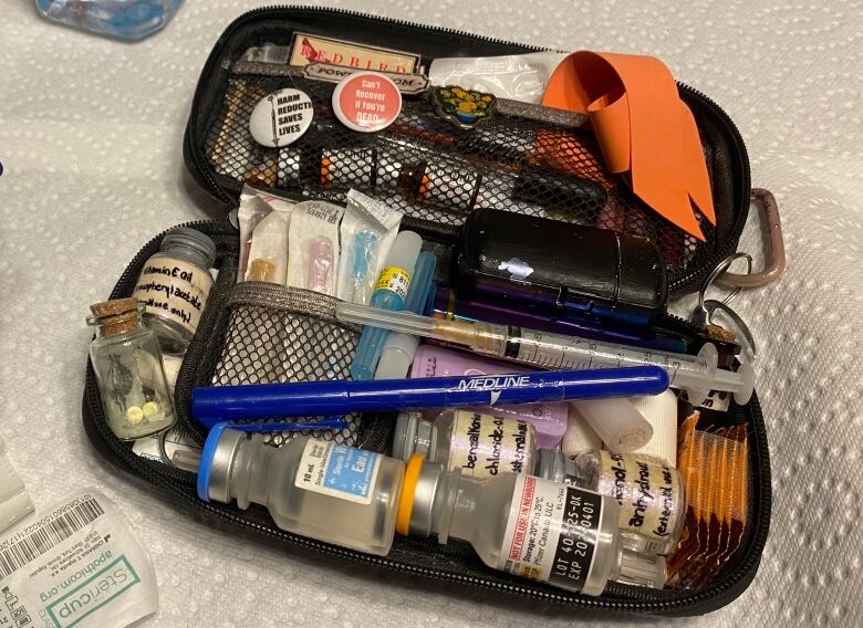 A black case is filled with different, small items used as part of a prescription opioid kit.