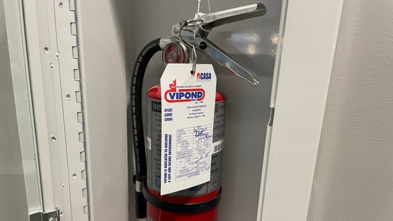 A fire extinguisher in a cabinet.