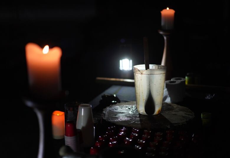 A candelit altar with a cup used to deliver ayahuasca to people in a ceremony.