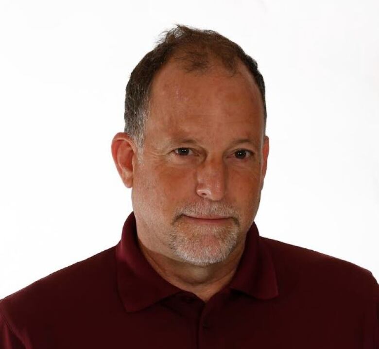 close up photo of white man wearing burgundy golf shirt