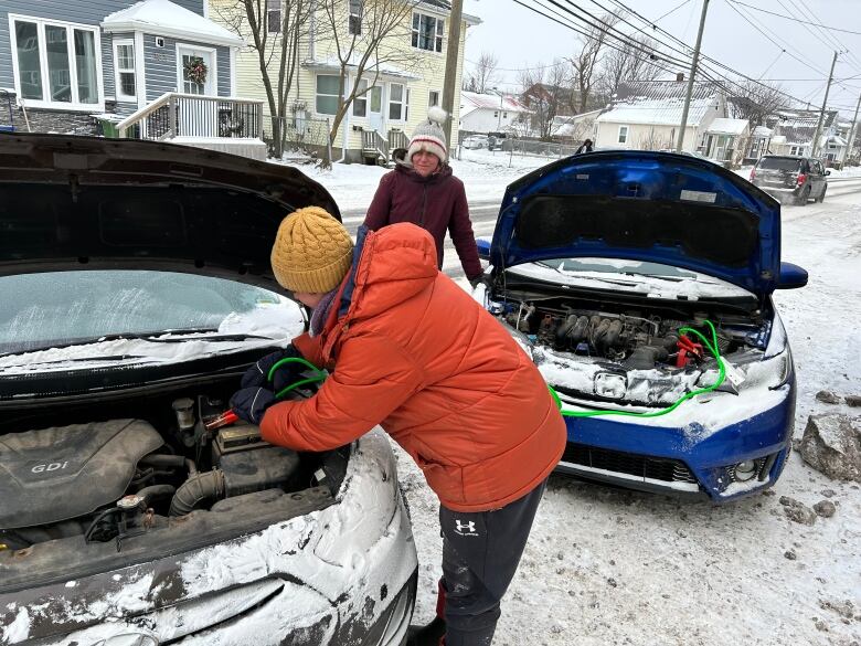 Hannah Gehrels attaches booster cables to her car on Queen Street in Charlottetown after it wouldn't start on its own in the extreme cold Saturday morning.