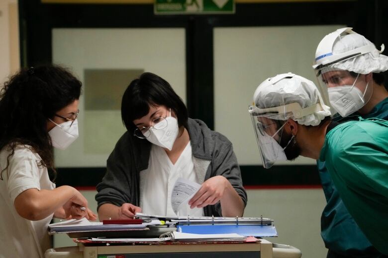 Doctors and nurses wearing masks in Rome work in a hospital.