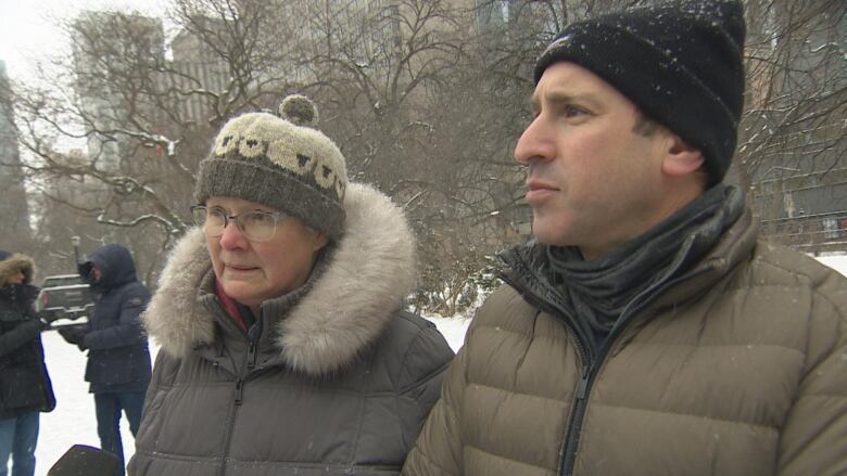 Two people, a man and a woman can be seen talking to a reporter behind camera.