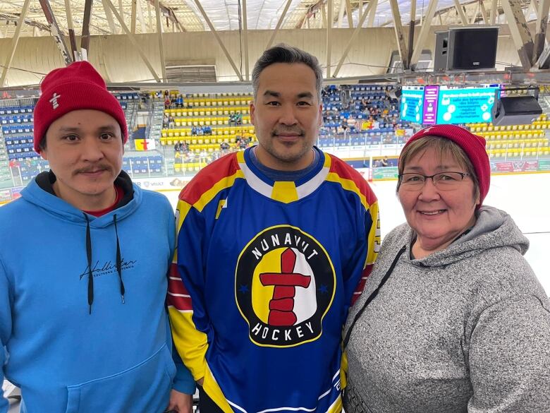 Three people in an arena.