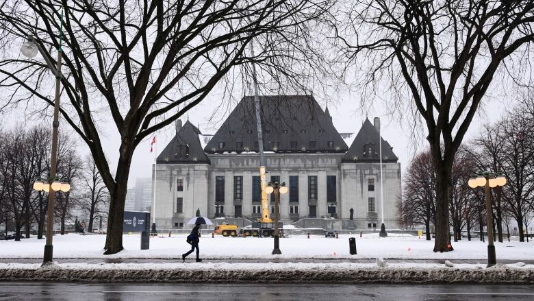 The Supreme Court of Canada building is seen from a distance outside on a winter's day.