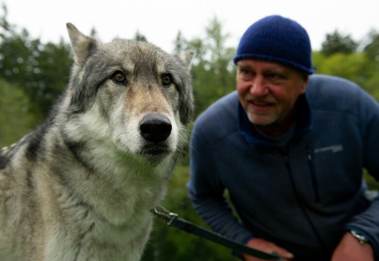 close up of a man and a wolf.