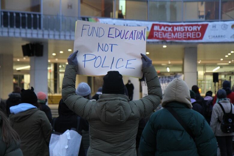 A woman holds a sign that reads 