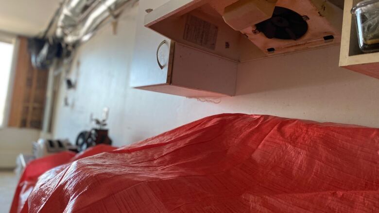 A tarp covers a stove in an apartment.