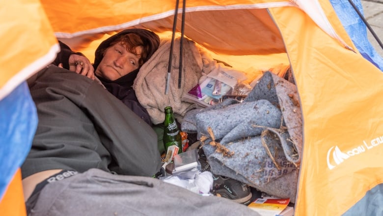 A person experiencing homelessness is inside a tent in Portland, Oregon.