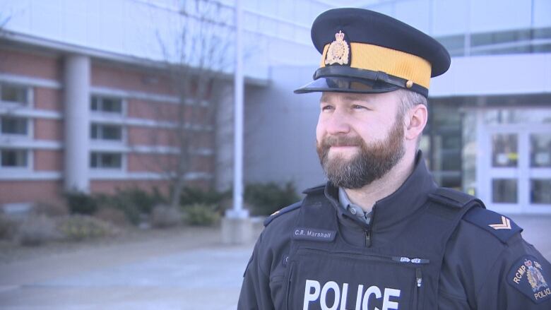 A police officer stands outside a building.