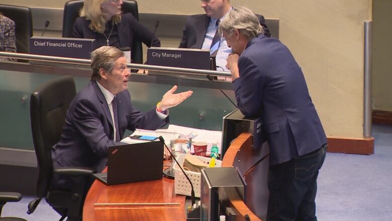 Mayor John Tory talks with Coun. Gord Perks during a debate about studying new taxes and fees for the city. The pair, who often disagree on policy, both voted in favour of the request of city staff to investigate possible new 