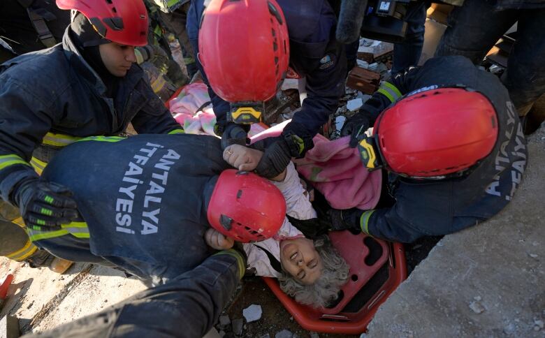 Rescue teams carry a survivor out from rubble.