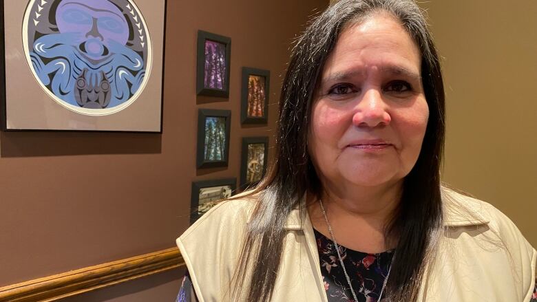 Beverly Jacobs stands in front of Indigenous artwork in her office at the University of Windsor.