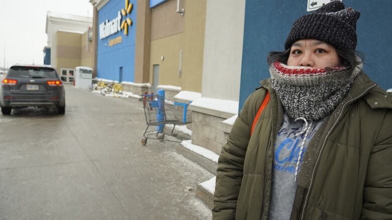 A woman stands in front of a Walmart sign.