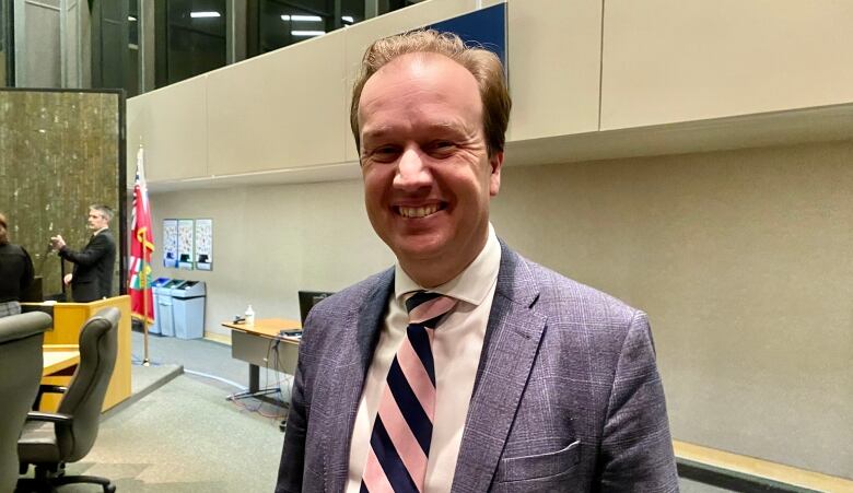 Paul Lefebvre in a blue suit and pink striped tie in council chambers