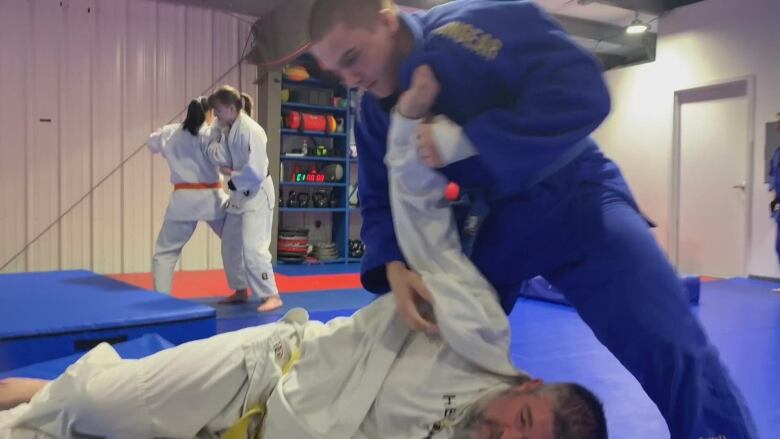 A Judoka throws a man to the ground. 