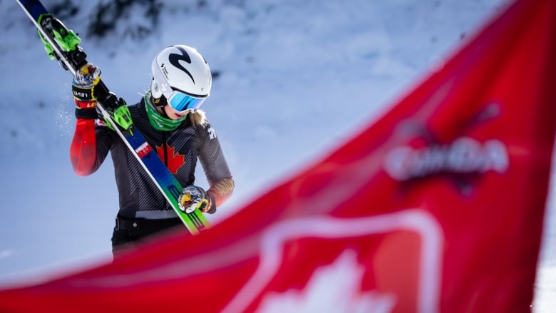 A woman holds her skis 