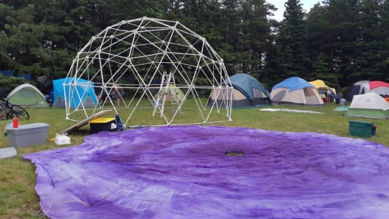 A dome is installed on the Winnipeg Folk Festival campground. A silk canvas is placed on the ground in front of it.