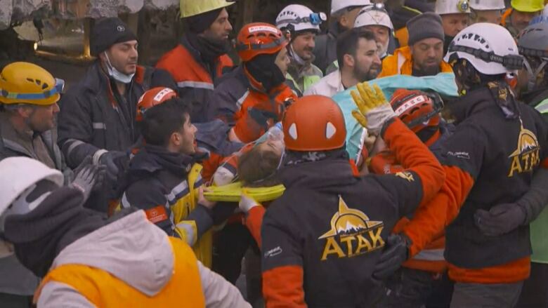 Men carry a woman on a stretcher.