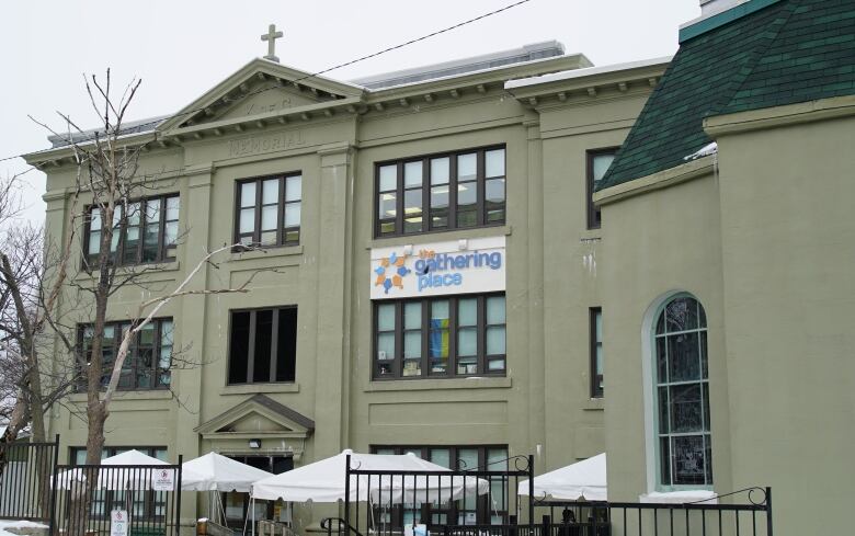 An old three-storey convent with a cross on the roof, and a sign on the second floor that says The Gathering Place.