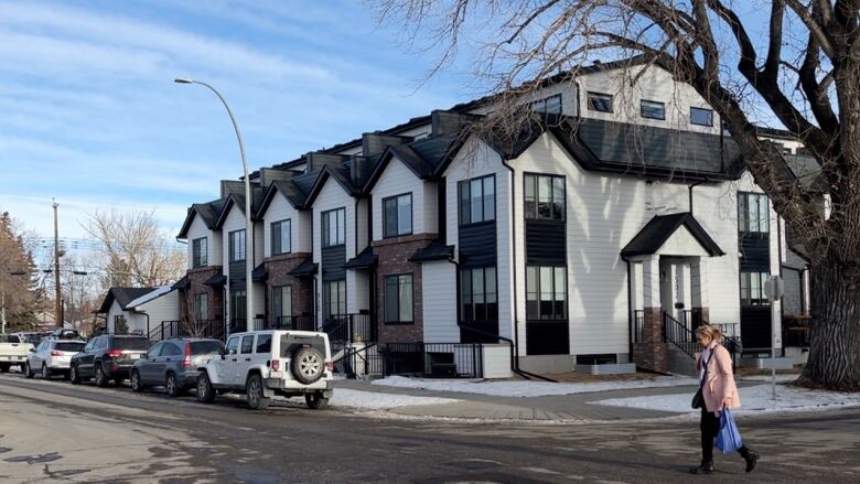 A woman walks past a multi-family townhouse project in Inglewood. 