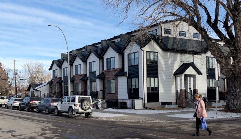 A woman walks past a multi-family townhouse project in Inglewood. 