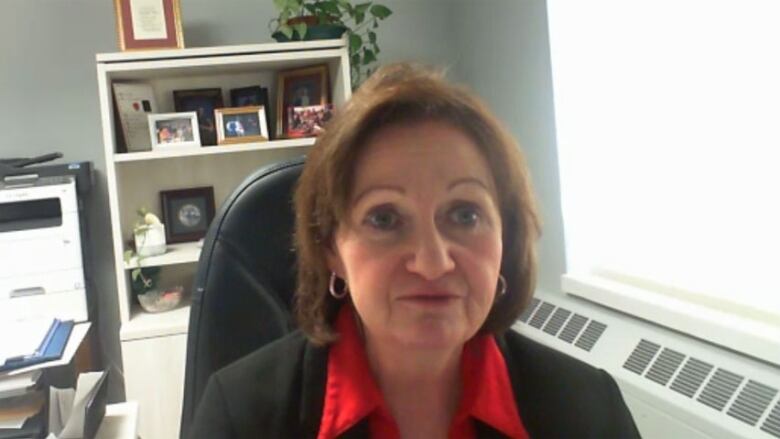 A portrait of a woman seated in an office.