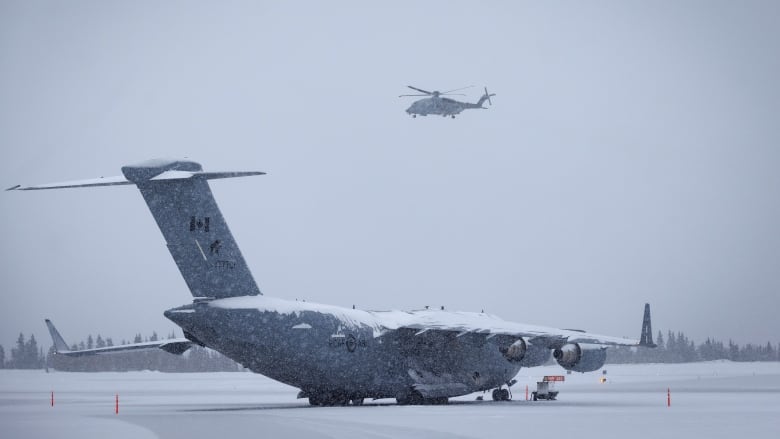 A helicopter is seen flying through winter weather in the Yukon.