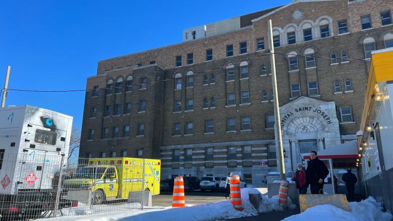 Hospital in winter time, with an ambulance out front.