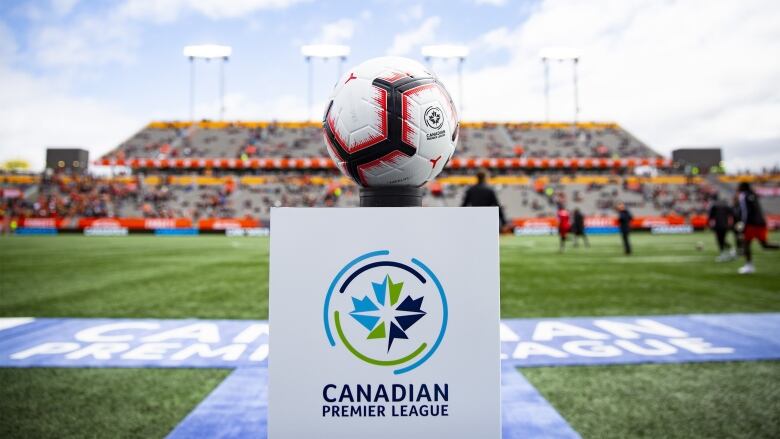 A soccer ball sits on a pedestal featuring Canadian Premier League branding.