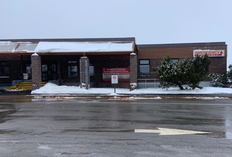 A building on a snowy day. One sign on the building says 