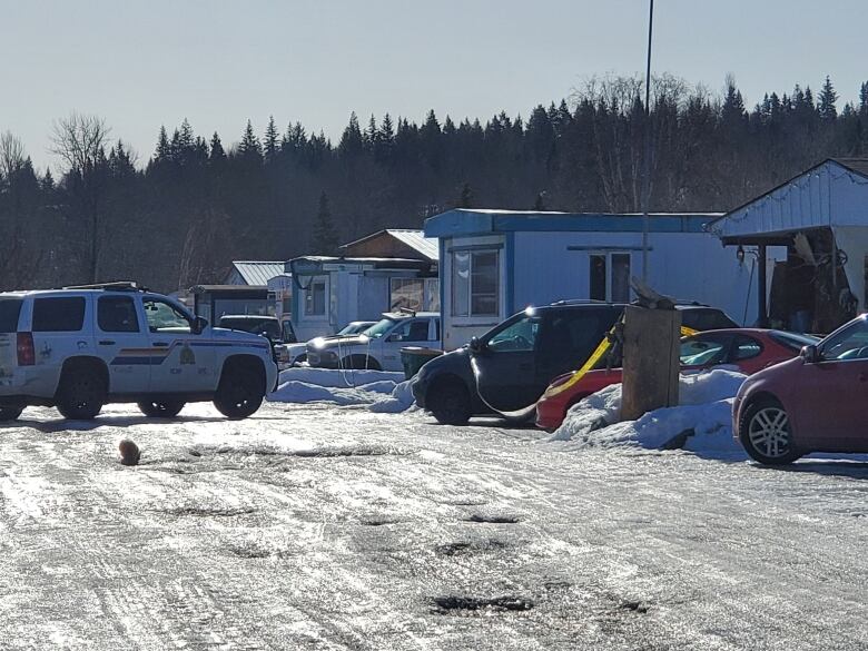 An RCMP SUV faces a number of mobile homes in an apparent trailer park.